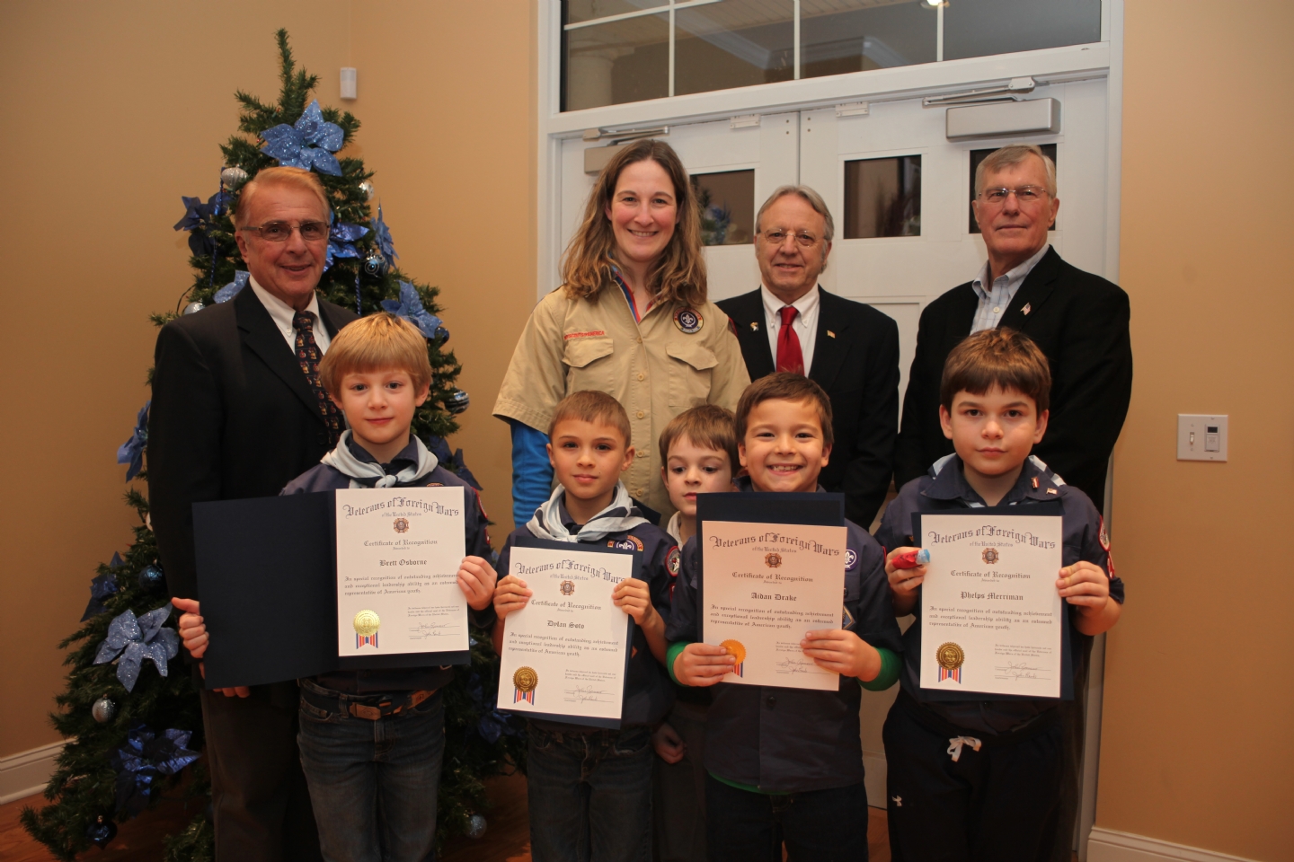 At the December holiday dinner of Metacomet VFW Post 1926 in Simsbury, five certificates of recognition were distributed to members of the Simsbury Cub Scout Den 11 of Boy Scout Pack 276 for their outstanding contribution of $486 to the Post’s ‘Adopt a Vet’ program.  The Cub Scouts raised the donation by selling Boy Scout popcorn. The Post’s ‘Adopt A Vet’ program has been in place for just over one year with the long term objective to help individual veterans stand on their own in a sustaining lifestyle.  The program recently helped a disabled veteran financially while appealing his disability with the Veterans Administration and helped a homeless veteran get back on his feet.  The Cub Scouts responsible for the donation, with their certificates, are (left to right): Brett Osborne, Dylan Soto, Aiden Drake, Phelps Merriman. Missing from the picture is Caleb Deems.  In the back row are (left to right): John Romano, Commander, VFW Post 1926; Suzanne Osborne, Den Leader with her son, Josh; John Lamb, Quartermaster of Post 1926; and John Fox, Senior Vice Commander of Post 1926. 

